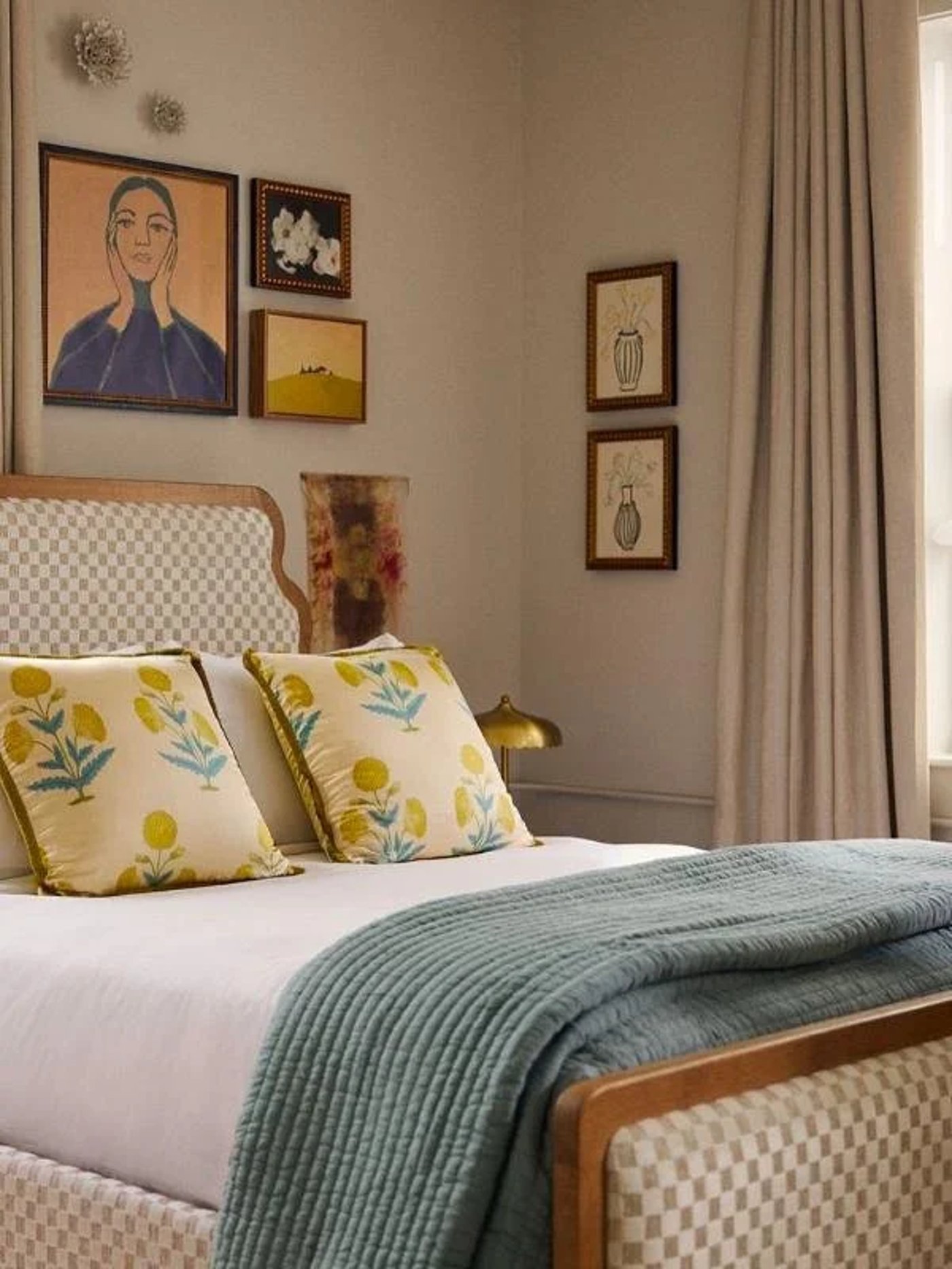 This cozy, eclectic hideaway feels like a private library in a storied European townhouse, wrapped in warm terracotta tones and punctuated by a witty collection of art. The dramatic, arched floor lamp casts a golden glow over plush upholstery, creating the ultimate sanctuary for slow sips and deep conversation.