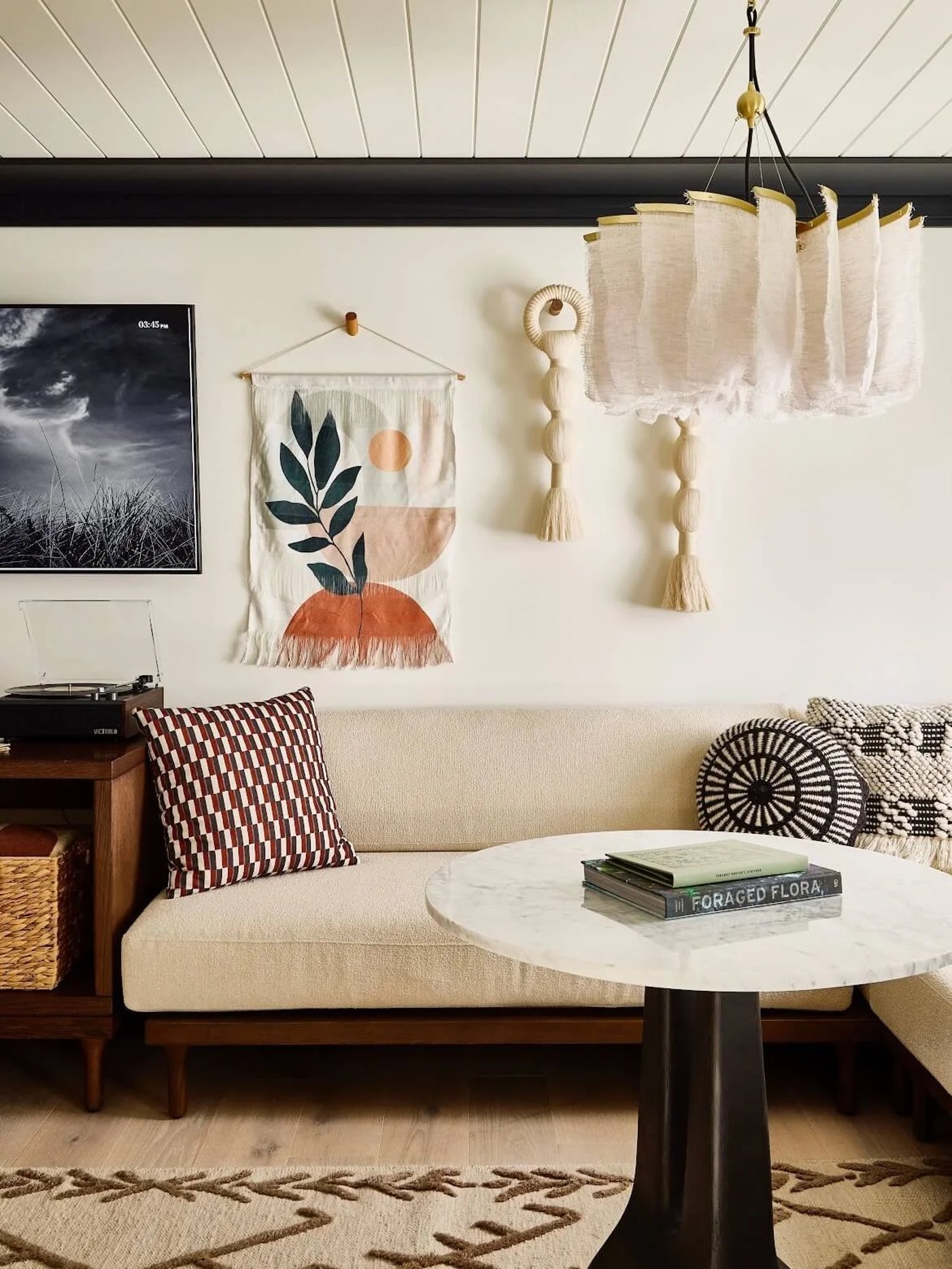An architectural masterpiece defined by its grid-patterned woodwork and a whimsical light installation that mimics floating petals. The space expertly balances precision with soulful textures, blending high-wattage chrome accents with the grounded warmth of vintage textiles and natural cane.