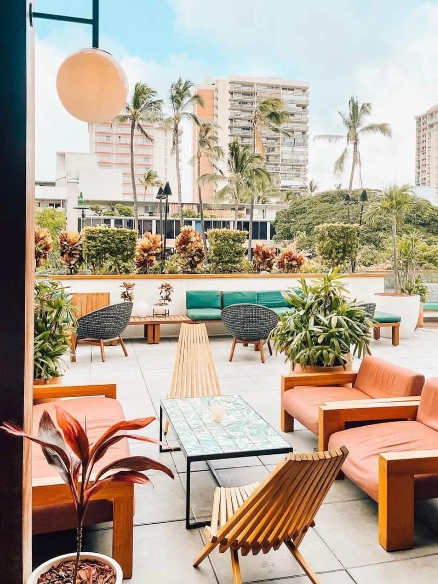 A lush, sun-drenched sanctuary that feels like a permanent vacation, blending sculptural rattan seating with vibrant botanical tiling. The space is a masterclass in tropical modernism, offering a sophisticated yet breezy atmosphere for golden hour cocktails.