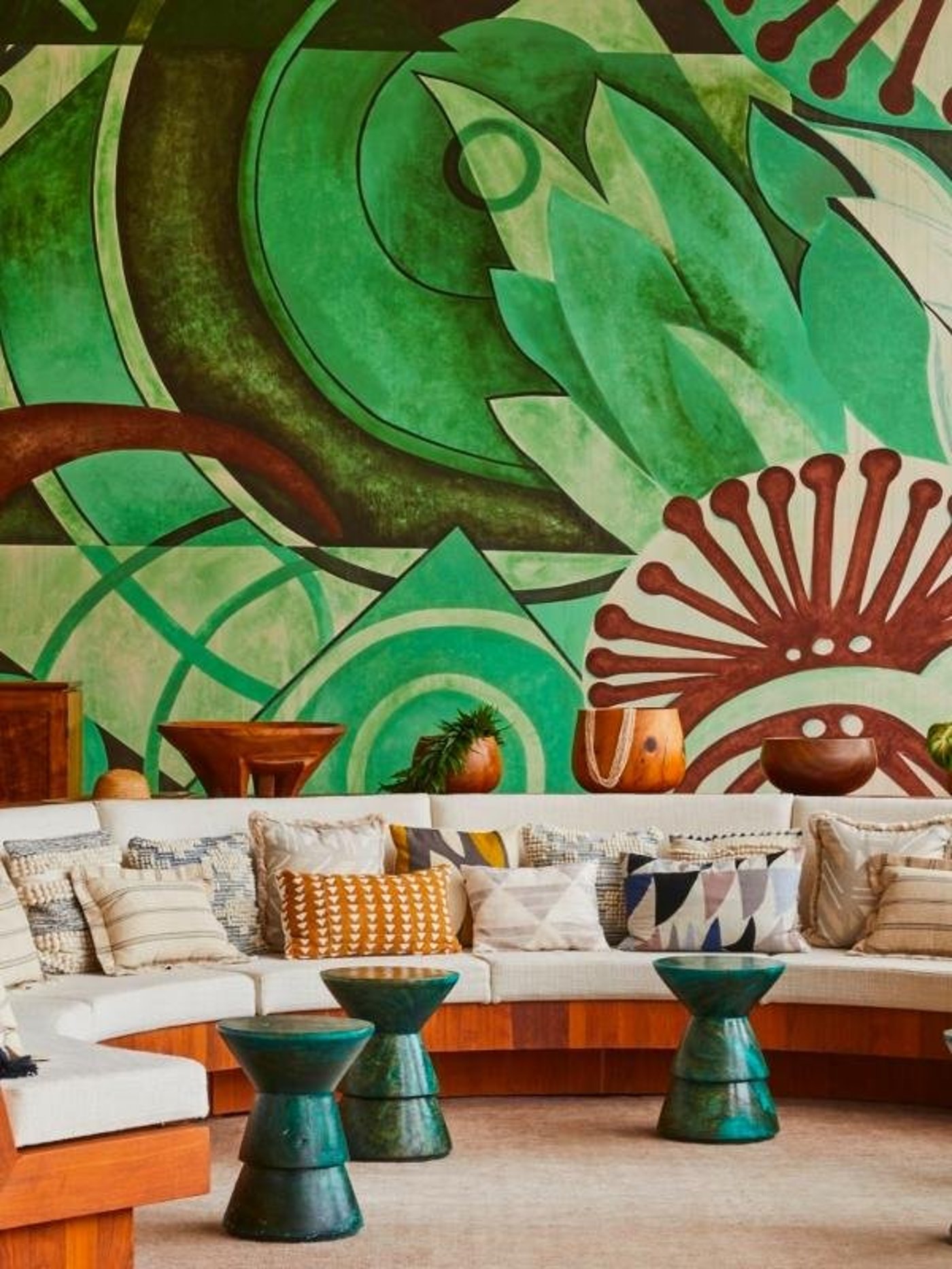 This captivating lounge is a masterclass in tropical modernism, anchored by a sweeping abstract mural that brings a lush, rhythmic energy to the space. The tactile interplay of patterned textiles and sculptural ceramic accents creates an environment that feels both curated and profoundly relaxing.