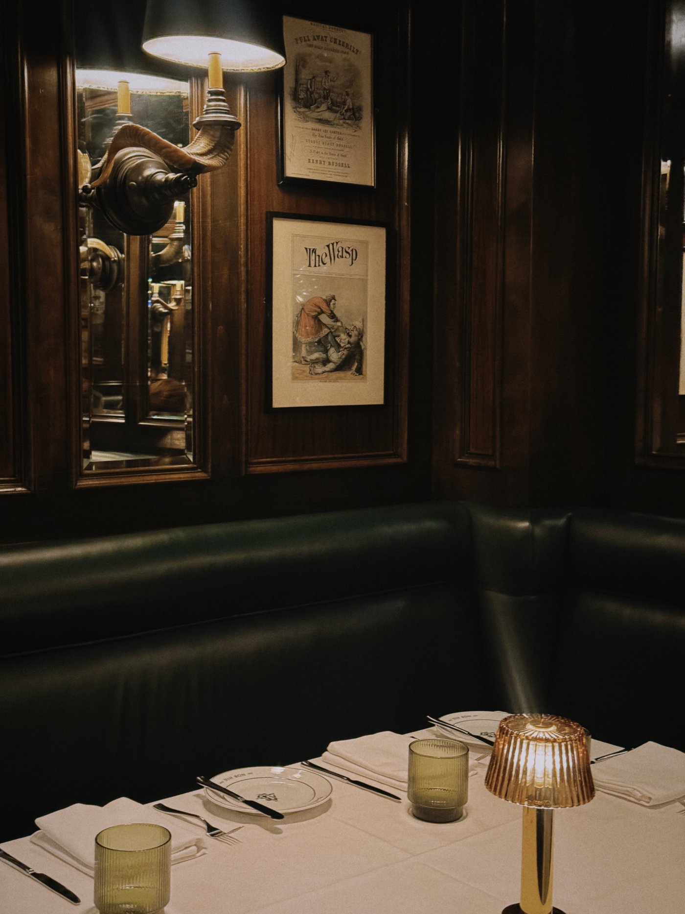 Wrapped in deep mahogany and forest green leather, this intimate corner evokes the timeless charm of a hidden European bistro. The soft glow of reeded glass lamps sets a seductive tone for long conversations over crisp linens.
