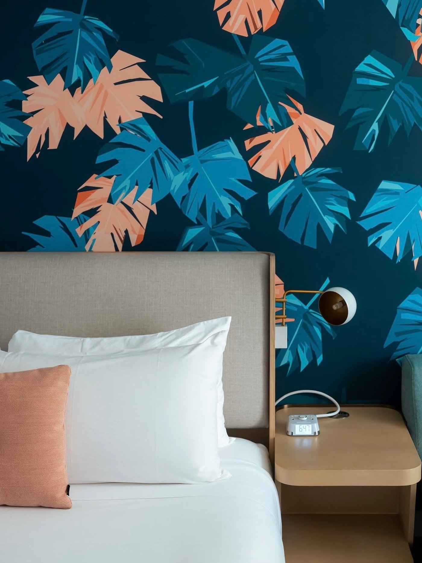 A masterclass in playful elegance, this guest room pairs a bold, graphic monstera-print wallpaper with refined textiles and warm brass accents. The space feels both energized and cocoon-like, offering a stylish escape for the modern traveler.