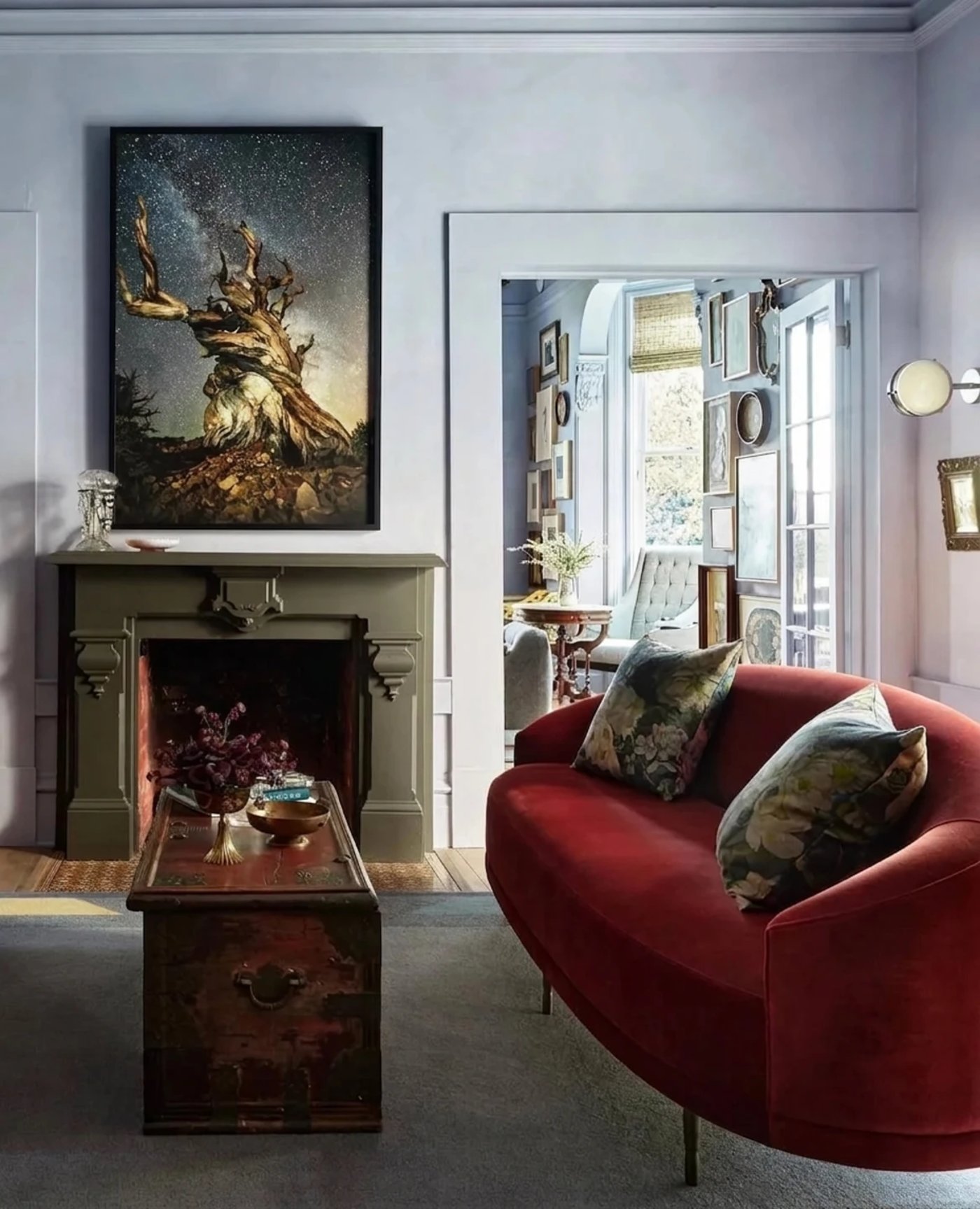 A masterclass in eclectic layering, this light-filled parlor balances moody, oversized art with the plush warmth of a velvet settee. The space feels like a private residence of a world-traveling collector, offering a sophisticated yet lived-in atmosphere that invites long conversations by the fire.
