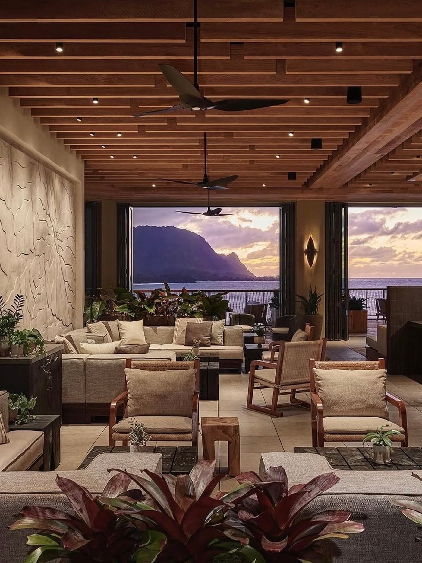This stunning open-air sanctuary blurs the line between high-design interiors and the raw beauty of the coast, featuring organic textures and a perfectly framed sunset view. It is the epitome of quiet luxury, where the rhythmic ceiling slats and soft linen textures invite hours of effortless relaxation.